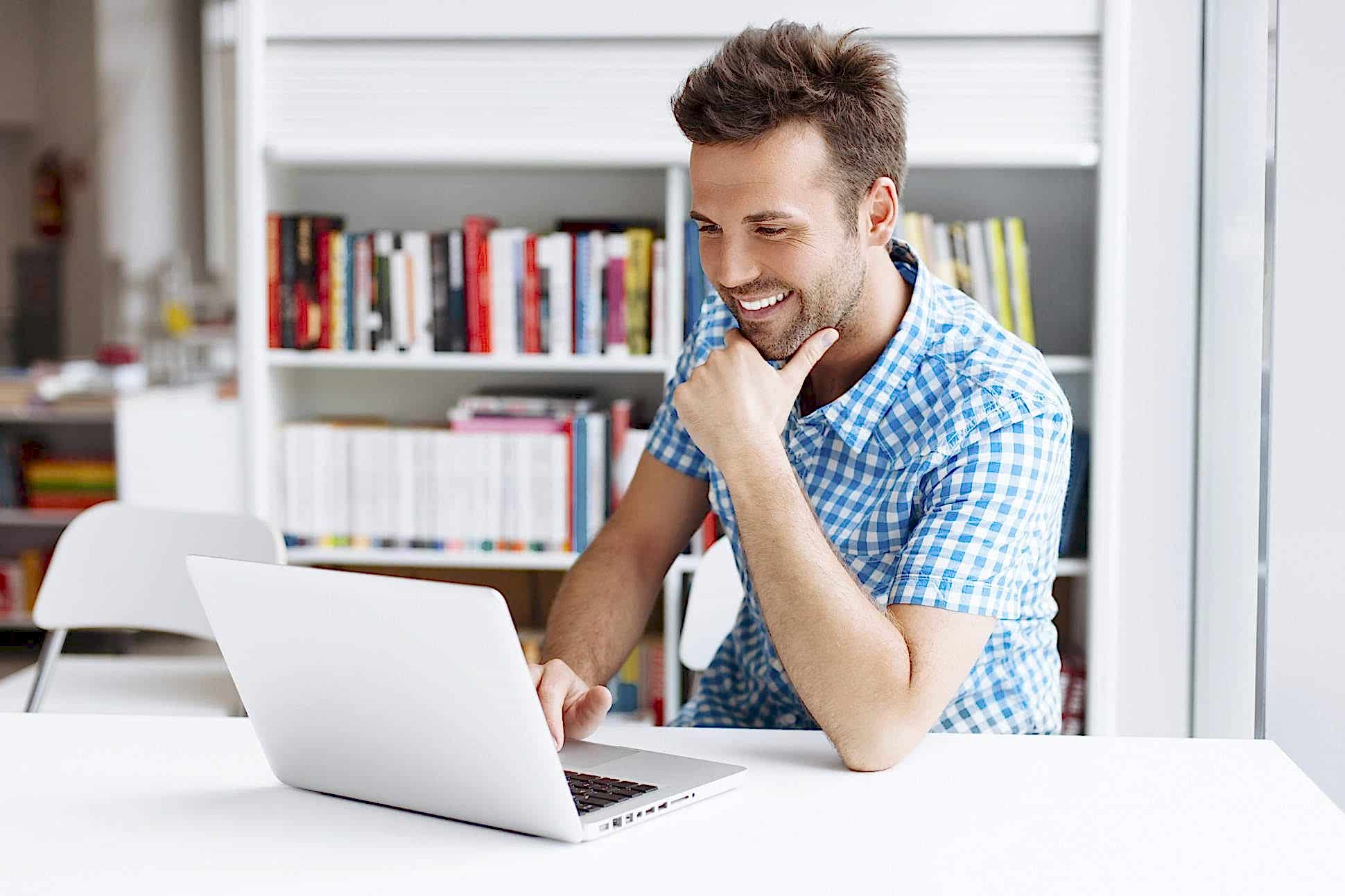 A man sitting at a table with his laptop.